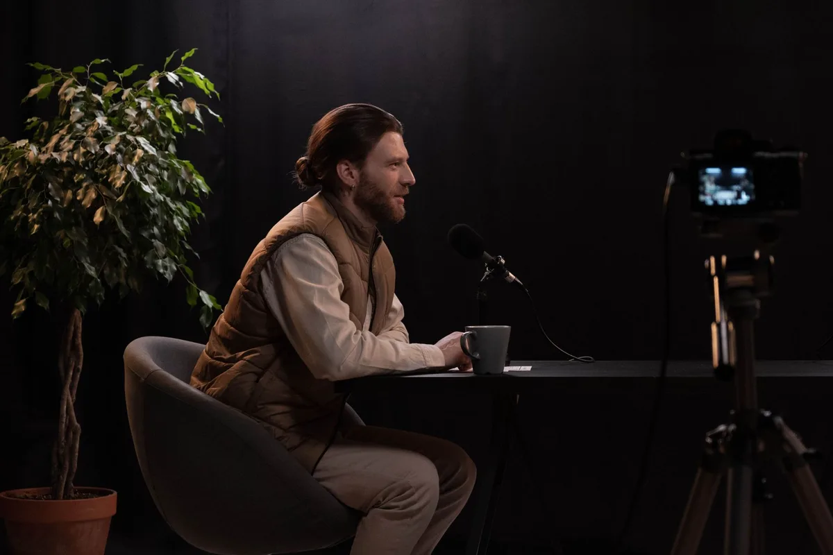 Un journaliste et son invité lors d'une interview en studio, l'atmosphère semblant tendue et inconfortable.