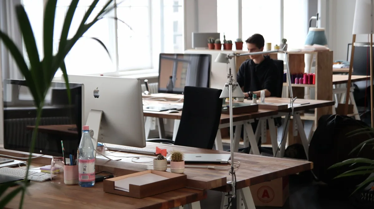 Personne consultant des documents professionnels avec notifications de réseaux sociaux visibles, illustrant une controve