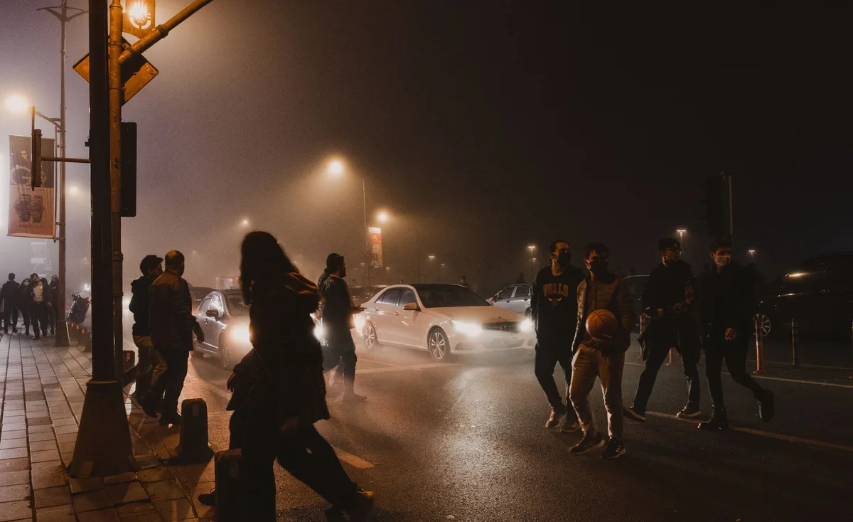 Scène de fusillade nocturne en milieu urbain avec tireurs masqués en noir et motos électriques