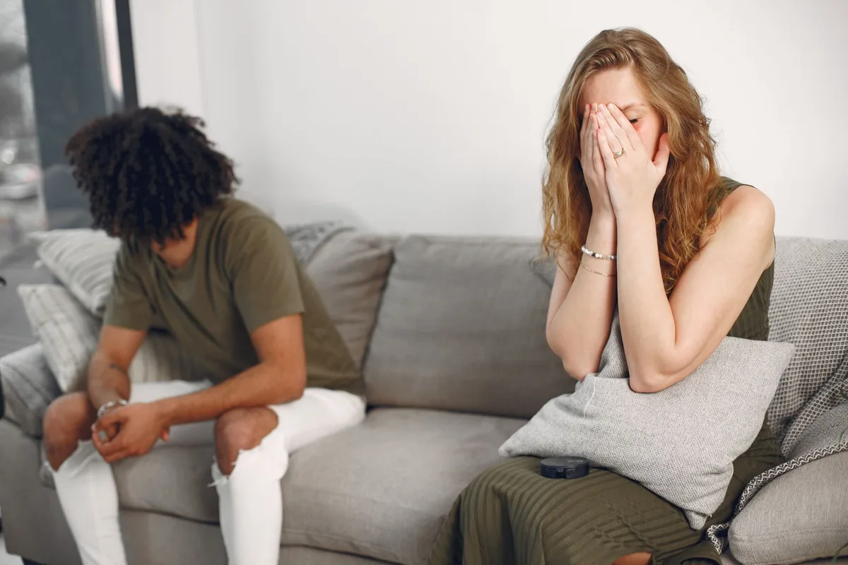 Couple assis éloigné l'un de l'autre dans un salon, illustrant le manque de connexion