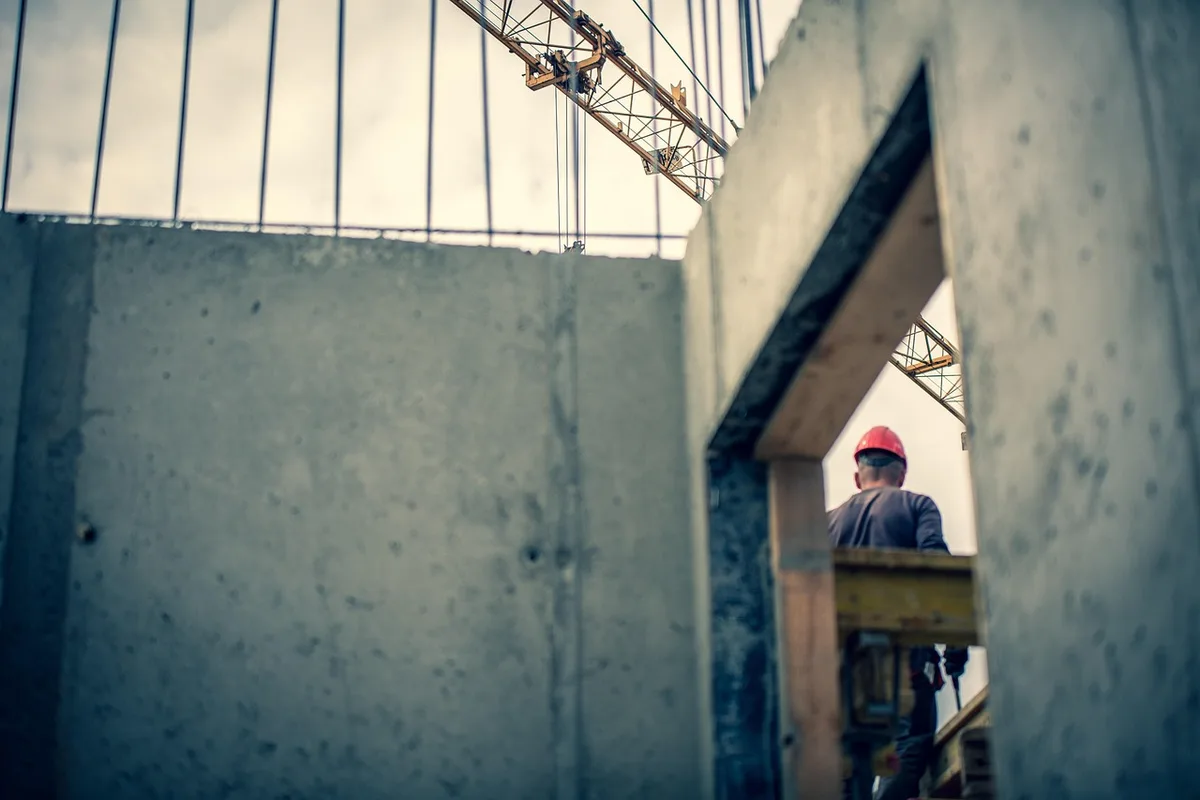 Chantier de reconstruction avec fondations et murs bas sur un ancien terrain résidentiel