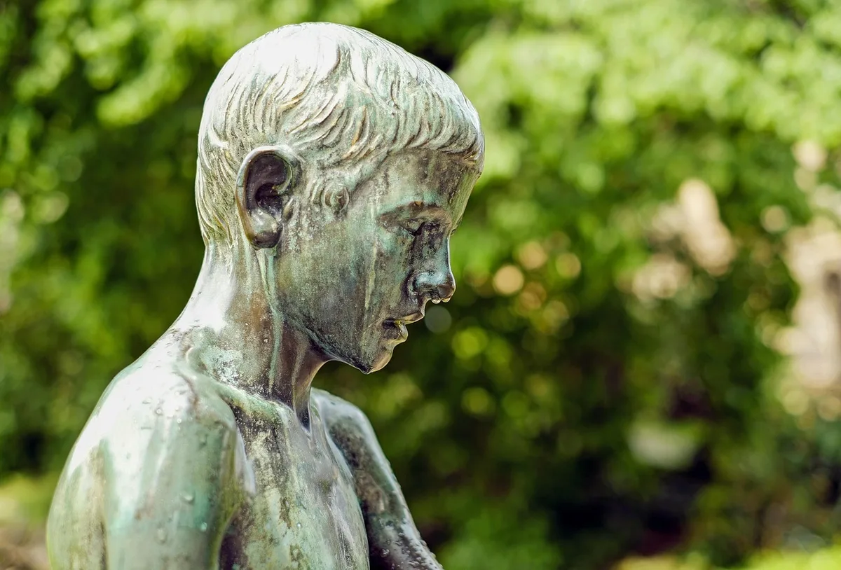 Veste d'enfant accrochée à une brèche dans une clôture de parc, étang en arrière-plan