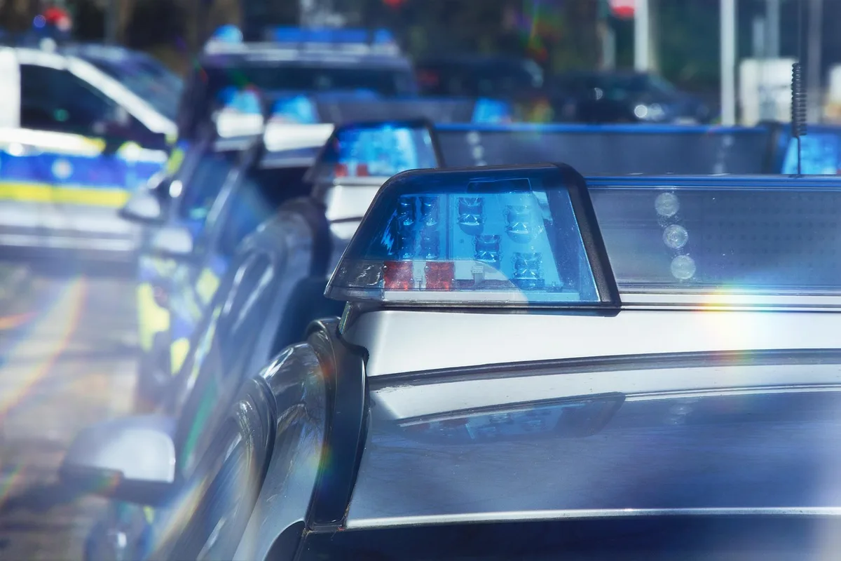 Policiers examinant une voiture la nuit devant une ruelle