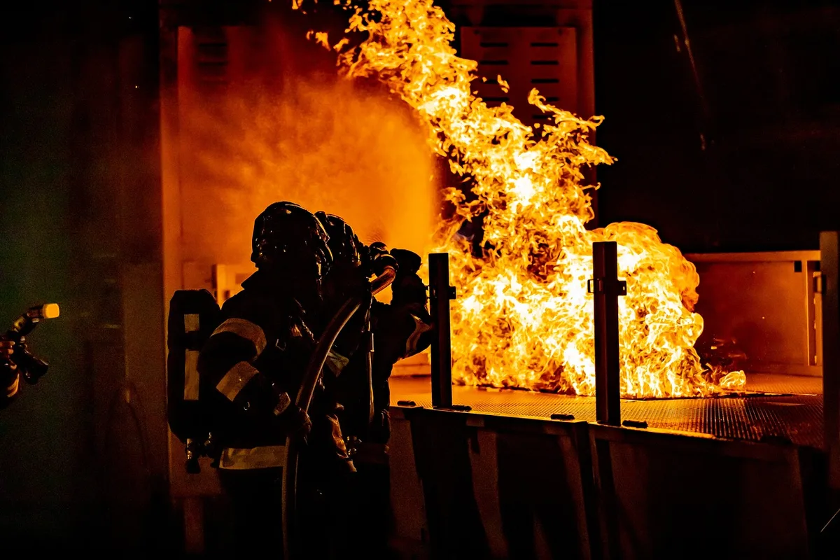Contre-feu mené depuis une crête avec fumée et lignes de feu