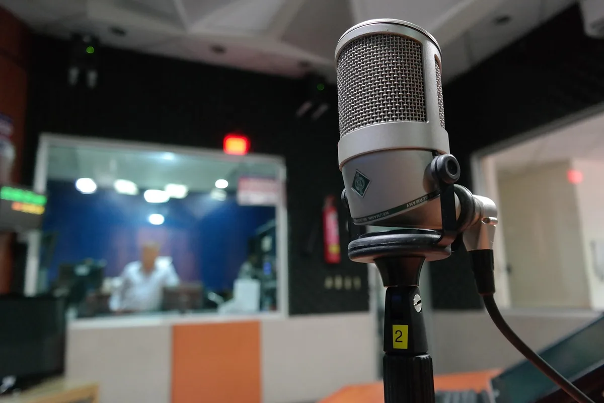 Animateur en studio radio vu de dos près d'un micro