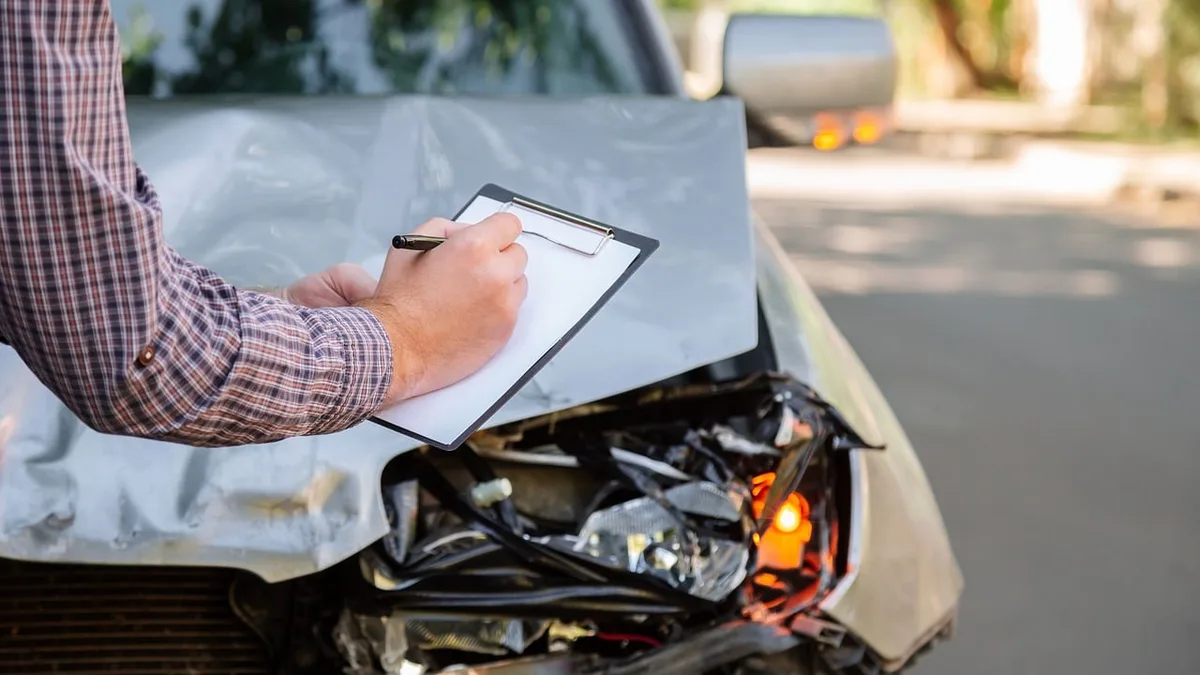 Voiture endommagée et papiers administratifs posés sur le capot