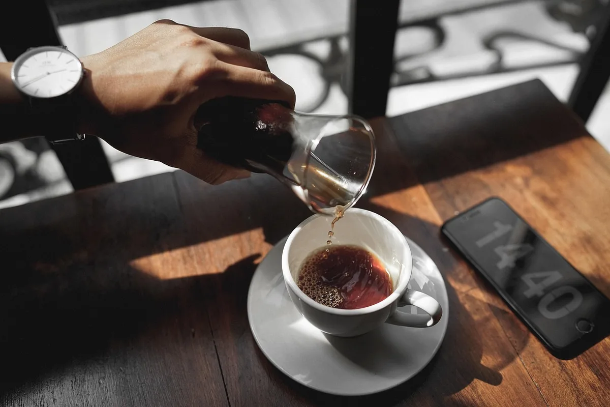 Silhouette d'un couple assis de dos à une table de café avec un micro et un carnet