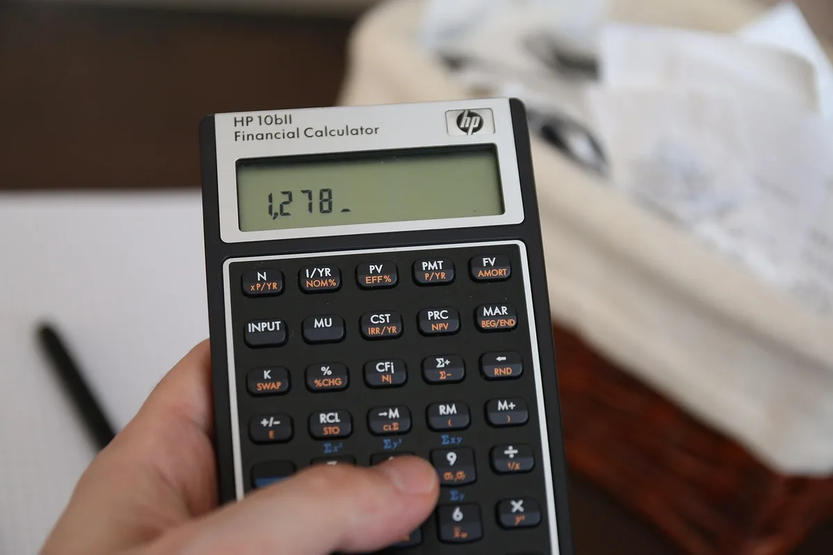 Factures et calculatrice sur une table représentant le taux d'effort des ménages