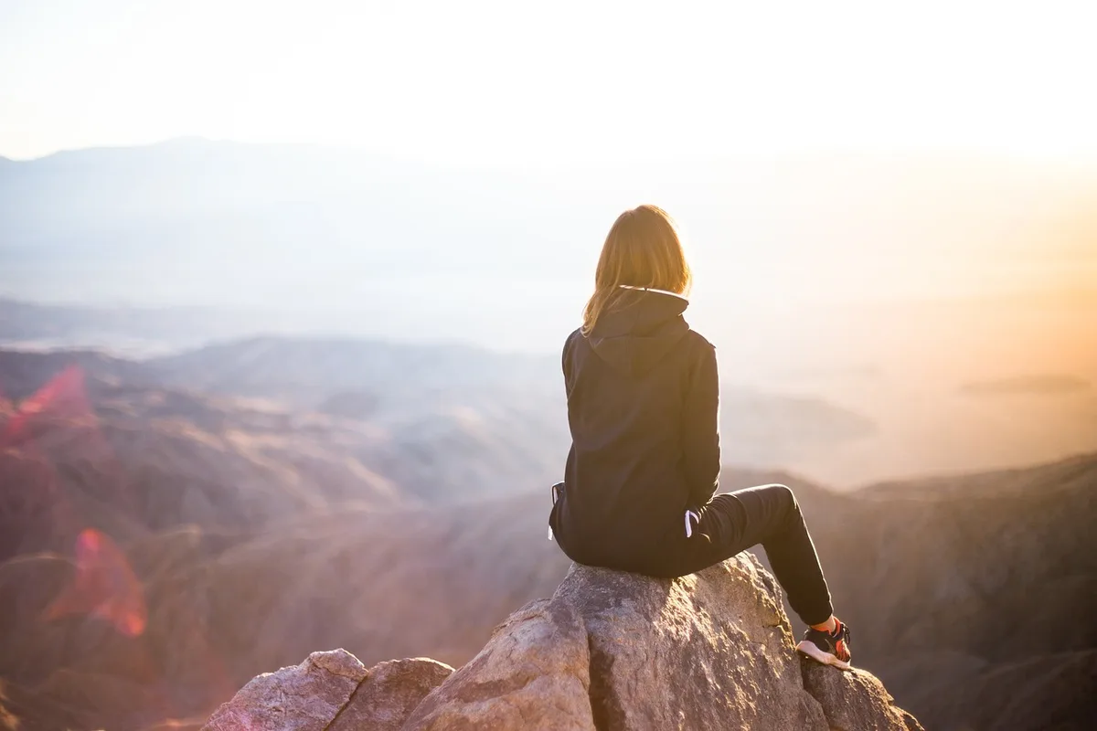 Femme regardant par la fenêtre, visage tourné de côté, moment de tristesse