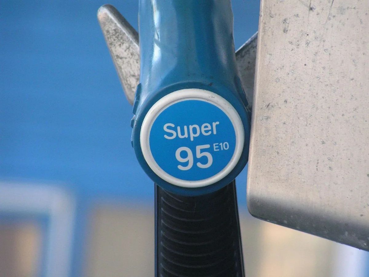Voiture à une station‑service avec compteur et carte routière illustrant les grands trajets