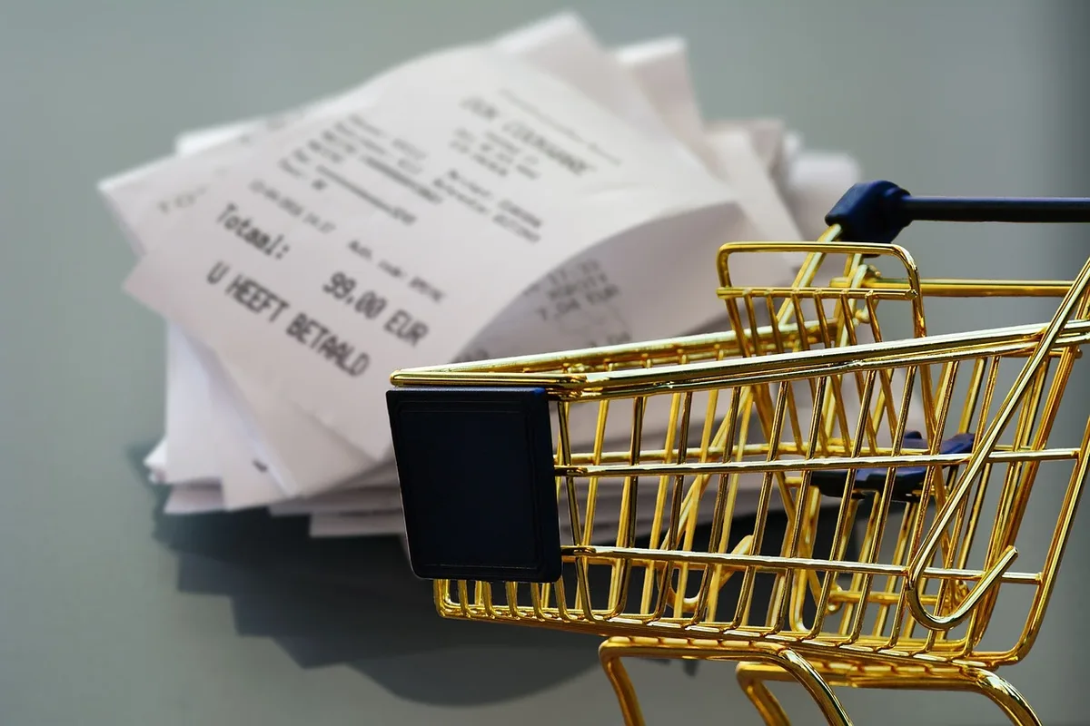 Personne anonyme faisant ses courses et regardant son ticket