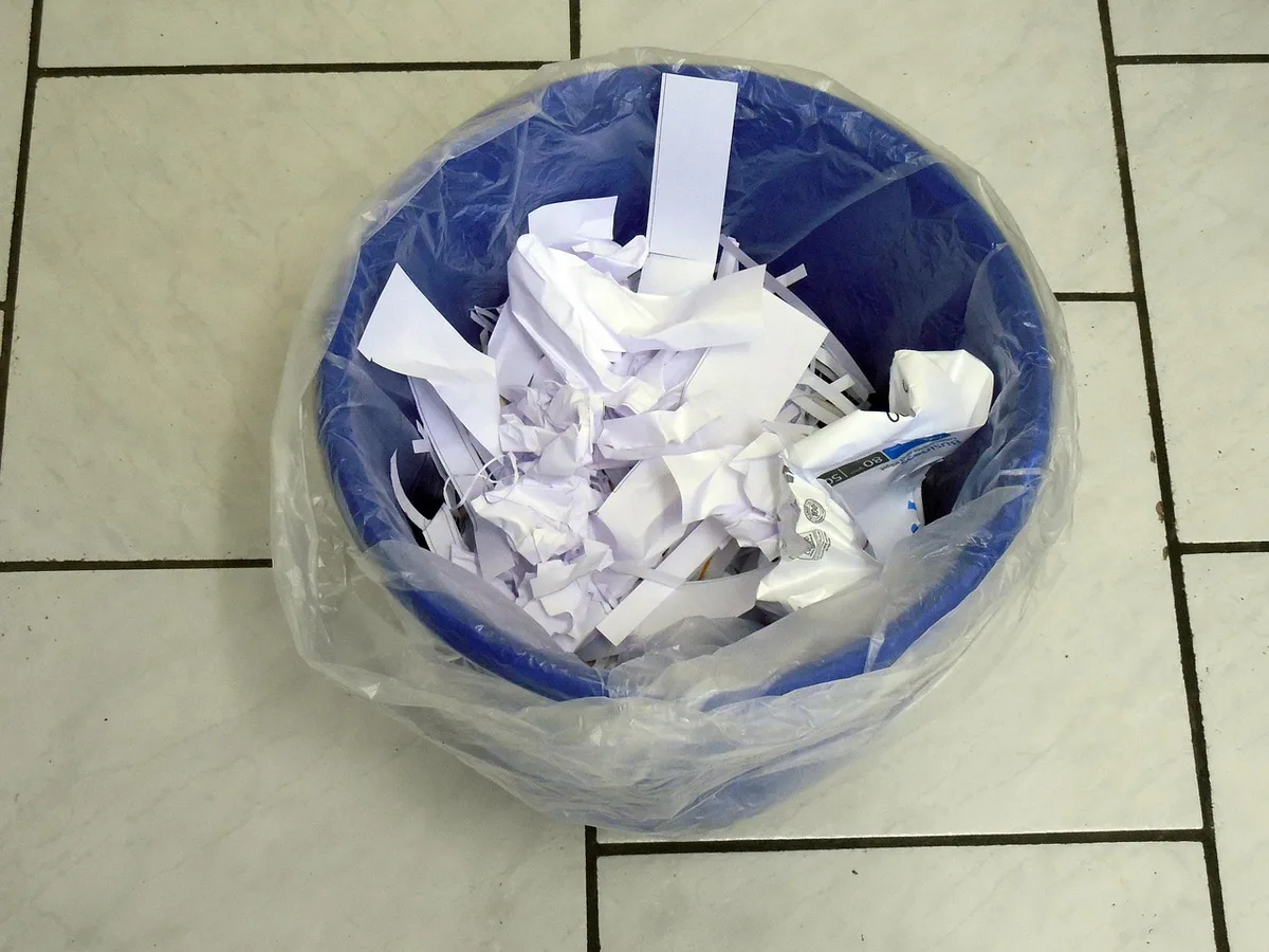 Benne à déchets médicaux avec gants et blouses dans un couloir d'hôpital